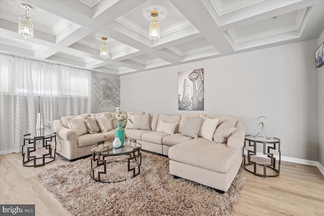 living room with light hardwood / wood-style floors, an inviting chandelier, ornamental molding, and coffered ceiling