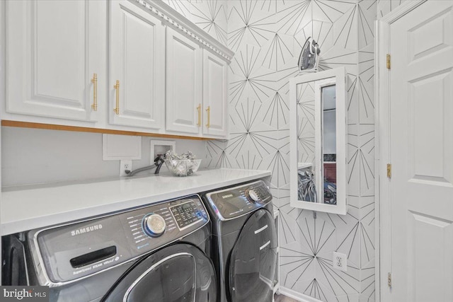 laundry area featuring washing machine and dryer and cabinets