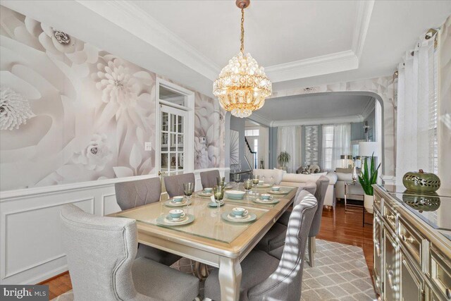 dining room with an inviting chandelier, light hardwood / wood-style flooring, and ornamental molding