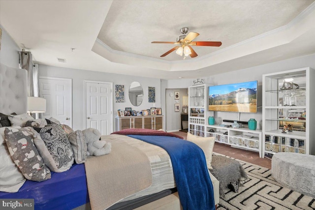 bedroom featuring a raised ceiling, ceiling fan, crown molding, and hardwood / wood-style flooring