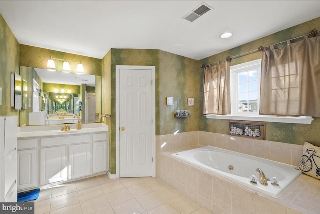 bathroom featuring tile patterned floors, vanity, and tiled bath