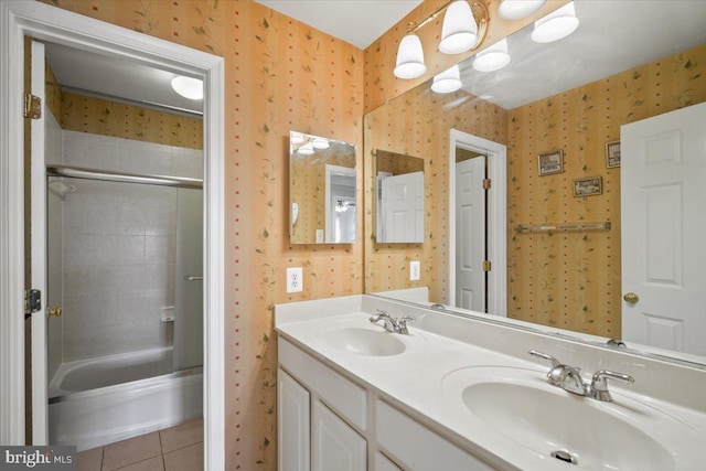 bathroom featuring tile patterned flooring, tiled shower / bath combo, and vanity