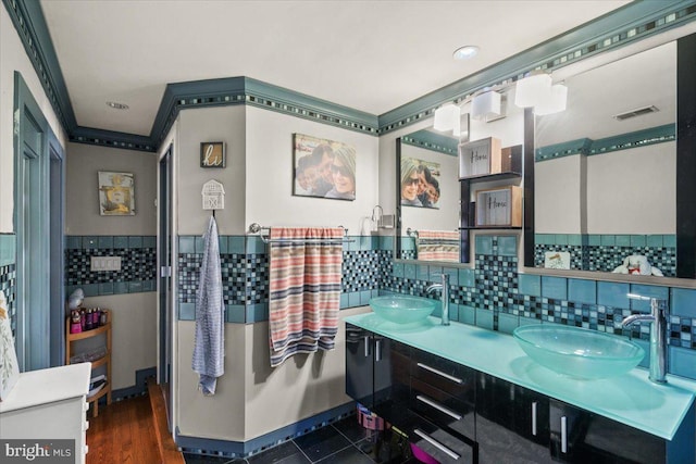 bathroom with decorative backsplash, wood-type flooring, and vanity