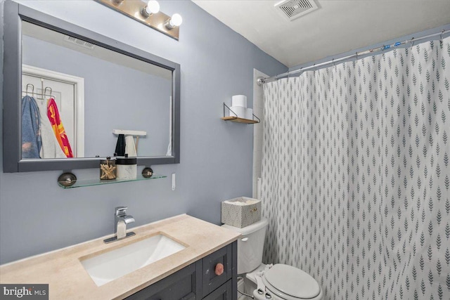 bathroom with vanity, curtained shower, and toilet