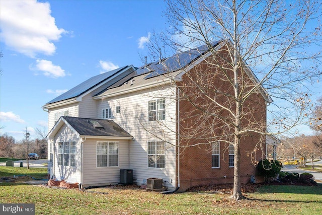 back of property featuring a lawn and central AC unit