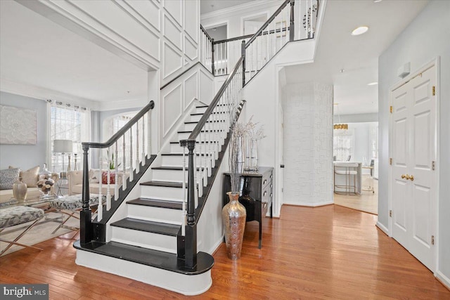 staircase featuring hardwood / wood-style floors and a notable chandelier