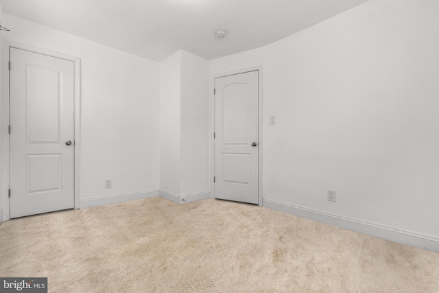 unfurnished room featuring light colored carpet