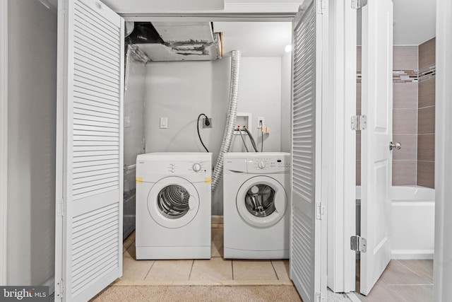 laundry room with light tile patterned floors and washing machine and clothes dryer