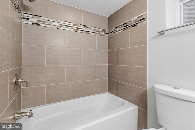 bathroom with tiled shower / bath combo and toilet