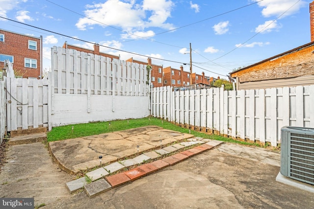 view of yard with central AC unit and a patio