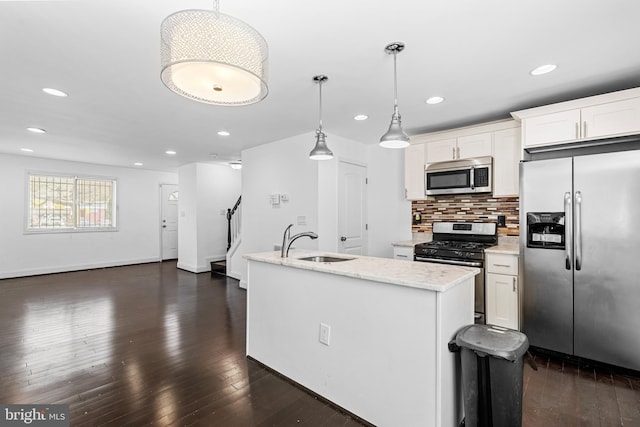 kitchen featuring appliances with stainless steel finishes, white cabinetry, hanging light fixtures, and sink