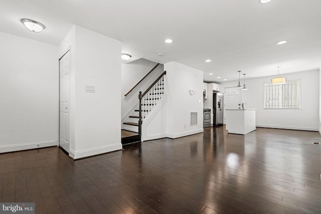 unfurnished living room featuring sink and dark wood-type flooring