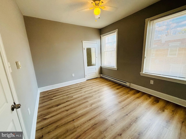 unfurnished bedroom featuring ceiling fan, a baseboard radiator, and light wood-type flooring