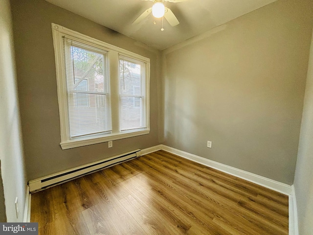 empty room featuring baseboard heating, ceiling fan, and wood-type flooring