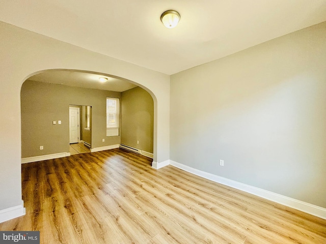 unfurnished room featuring hardwood / wood-style flooring and a baseboard radiator