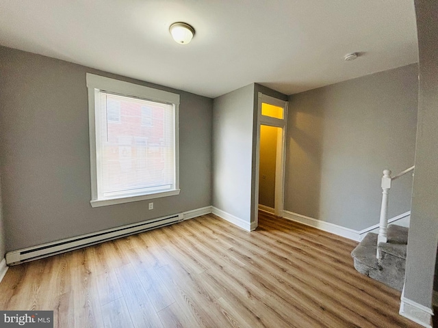 empty room with light wood-type flooring and baseboard heating