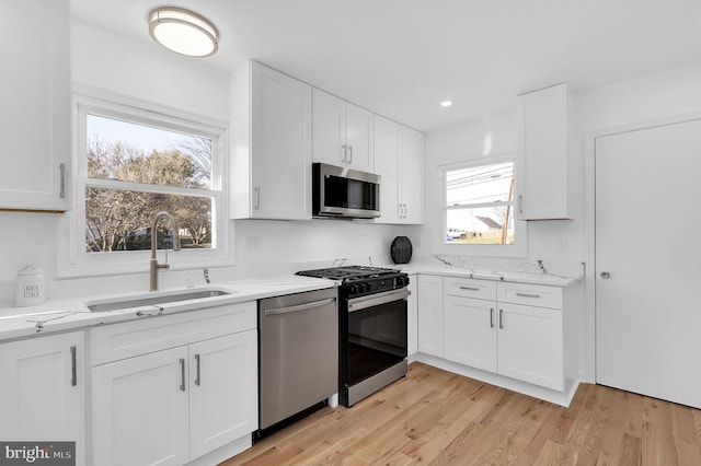 kitchen with white cabinetry, sink, and stainless steel appliances