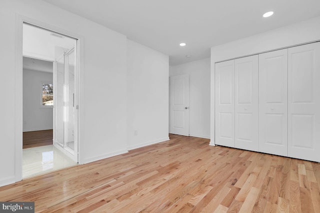 unfurnished bedroom with light hardwood / wood-style floors and a closet