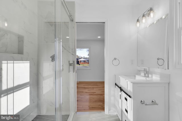 bathroom featuring wood-type flooring, vanity, and a shower with shower door