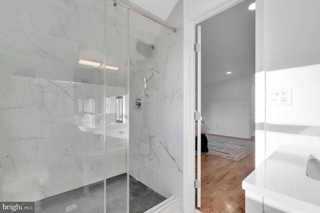 bathroom featuring hardwood / wood-style flooring and tiled shower