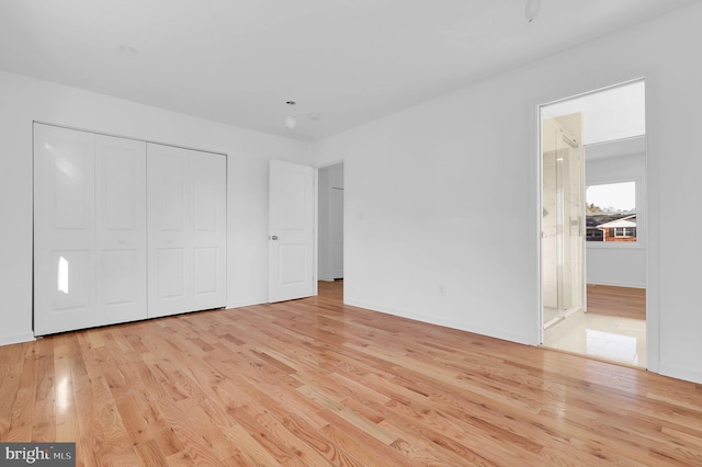 unfurnished bedroom with light hardwood / wood-style floors and a closet