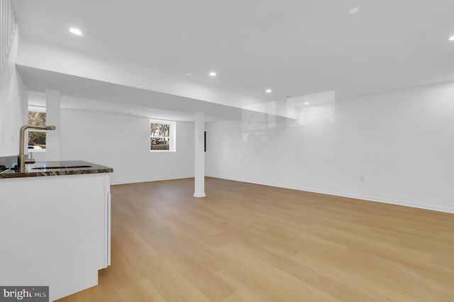 basement with sink and light wood-type flooring