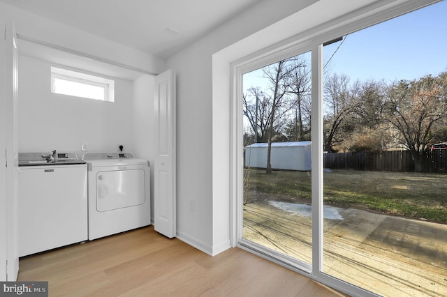 laundry area featuring separate washer and dryer and light hardwood / wood-style floors