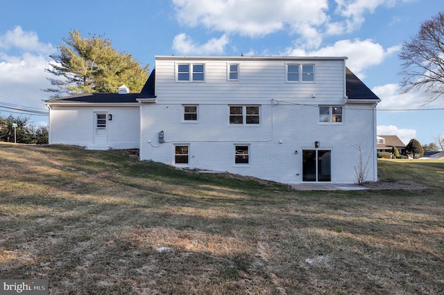 rear view of house featuring a lawn