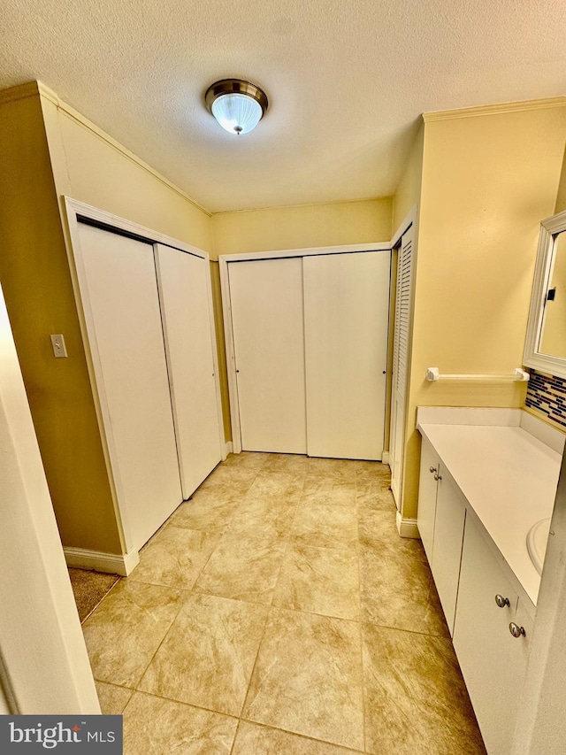 bathroom with vanity, a textured ceiling, and tile patterned flooring