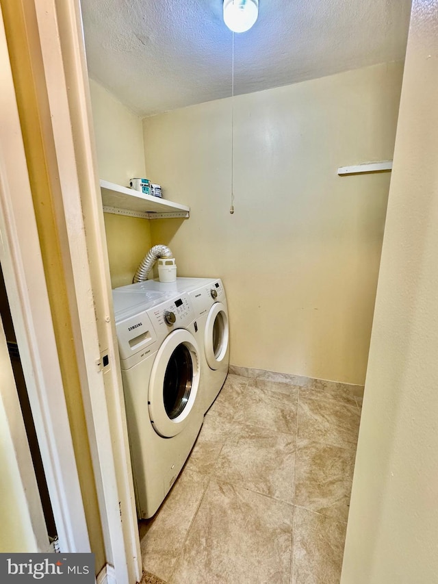 laundry room with washer and dryer and a textured ceiling