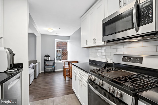 kitchen featuring decorative backsplash, light hardwood / wood-style flooring, white cabinets, and stainless steel appliances