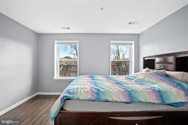 bedroom with hardwood / wood-style flooring and multiple windows