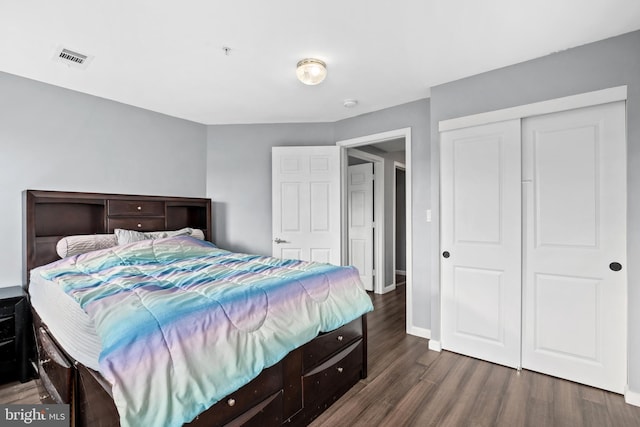 bedroom with dark hardwood / wood-style flooring and a closet