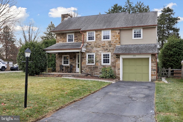 view of front of property featuring a porch, a garage, and a front yard