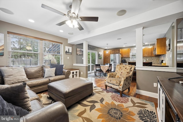 living room with light hardwood / wood-style flooring and ceiling fan