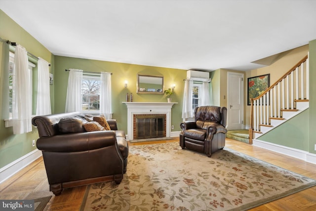 living room featuring parquet floors, a wall unit AC, and a brick fireplace