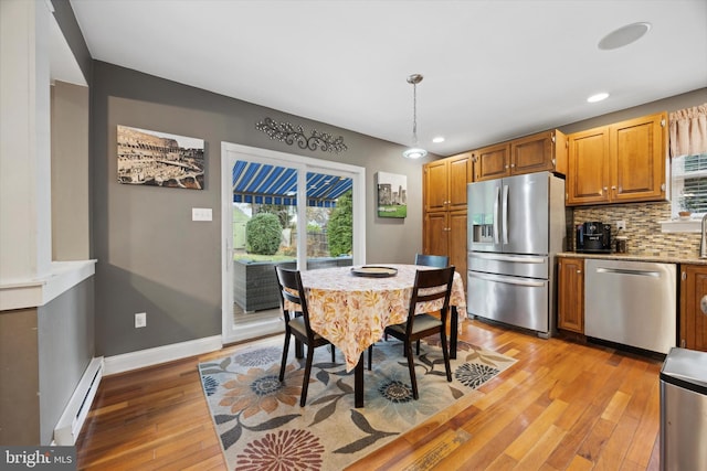 dining area featuring light wood-type flooring and a baseboard heating unit