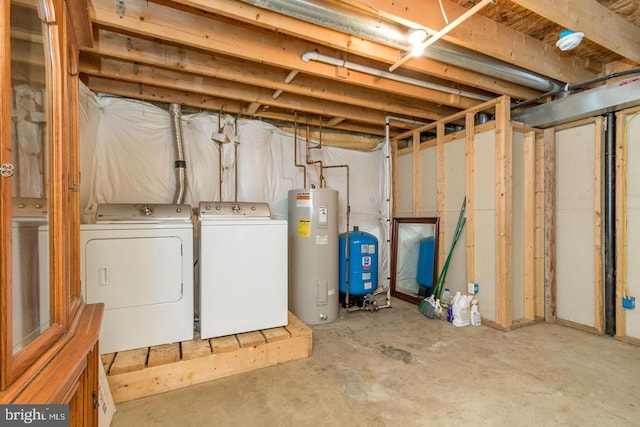 basement featuring electric water heater and separate washer and dryer