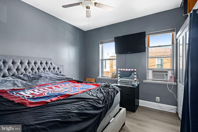 bedroom featuring wood-type flooring, ceiling fan, and cooling unit