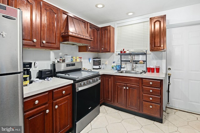 kitchen featuring decorative backsplash, sink, custom range hood, and appliances with stainless steel finishes