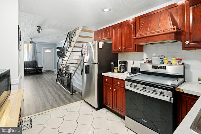 kitchen with decorative backsplash, appliances with stainless steel finishes, and premium range hood