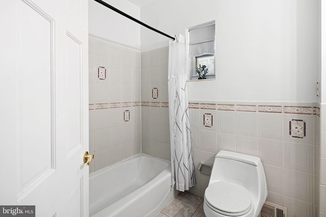 bathroom with toilet, shower / bath combo, tile patterned floors, and tile walls