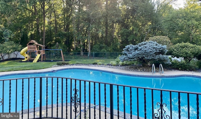 view of pool with a playground and a yard