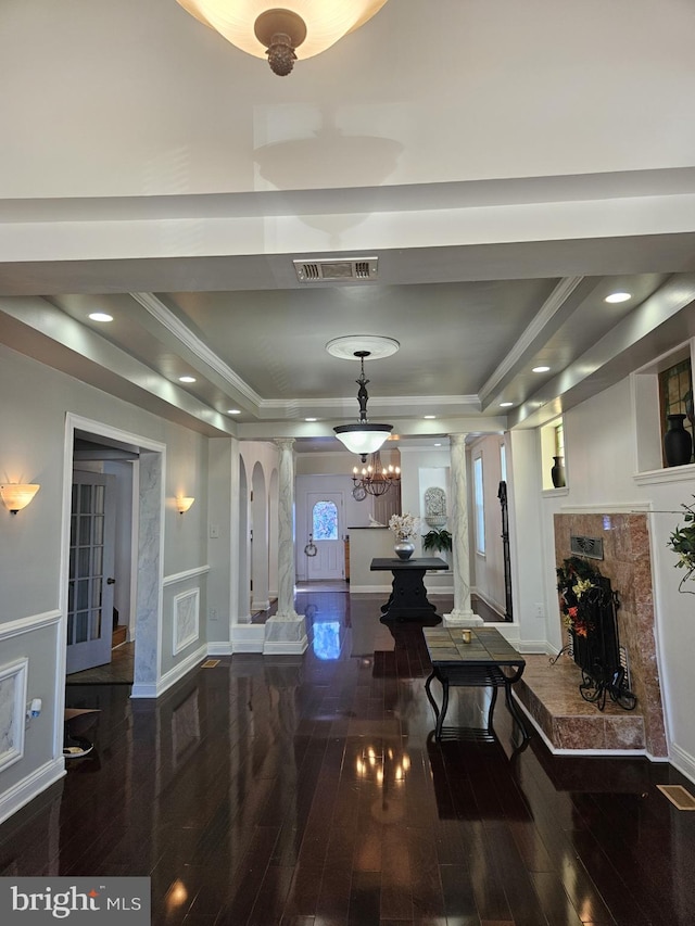 hall featuring a chandelier, hardwood / wood-style floors, a tray ceiling, and crown molding