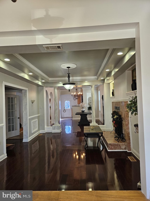 interior space with a tray ceiling, dark wood-type flooring, and a notable chandelier