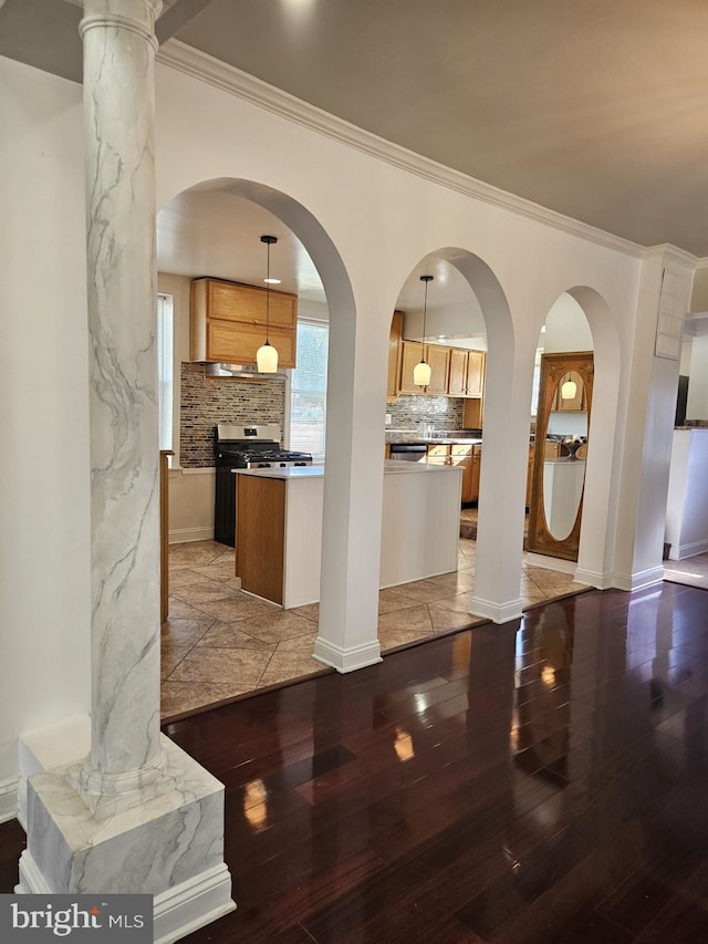 interior space with decorative backsplash, dark hardwood / wood-style flooring, a kitchen island, and hanging light fixtures