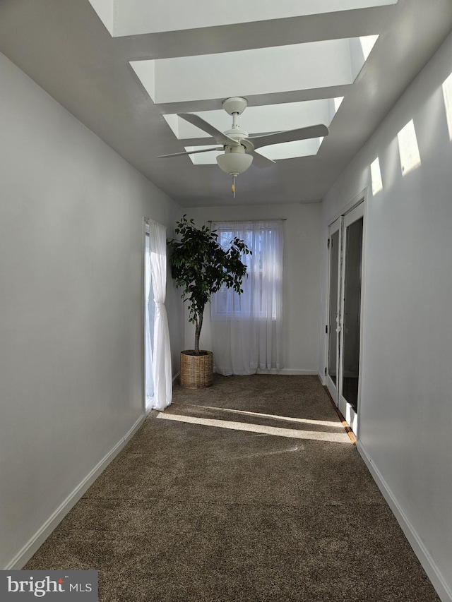 empty room with dark colored carpet and ceiling fan