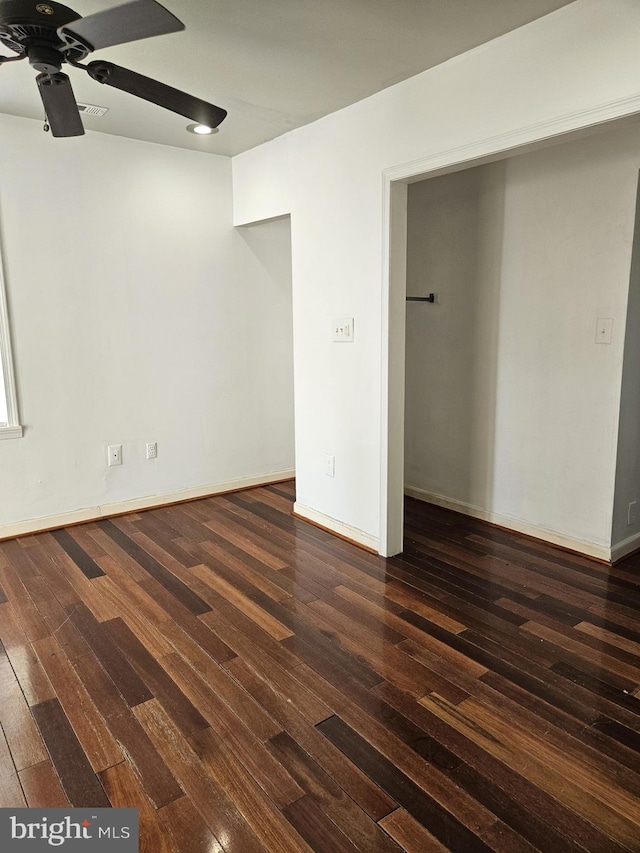 unfurnished room with ceiling fan and dark hardwood / wood-style flooring