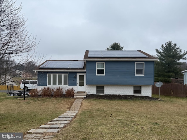 view of front of property with solar panels and a front lawn