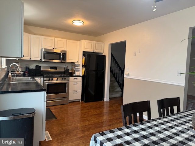 kitchen with white cabinetry, sink, dark hardwood / wood-style floors, and appliances with stainless steel finishes